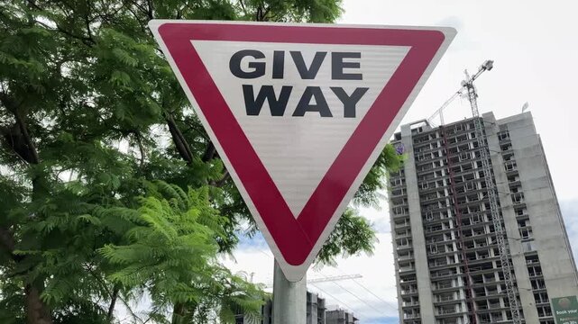 Islamabad, Pakistan - September 08 2025 (editorial): Give way traffic sign with cars and highways in the background. 