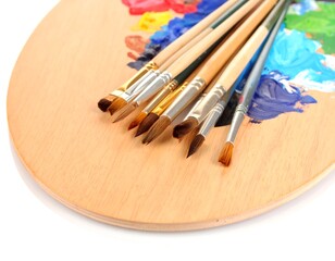 Paintbrushes on a palette with vibrant colors