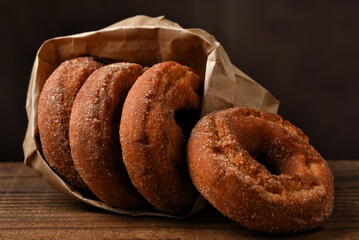 A brown paper bag filled with fresh baked Apple Cider Donuts.