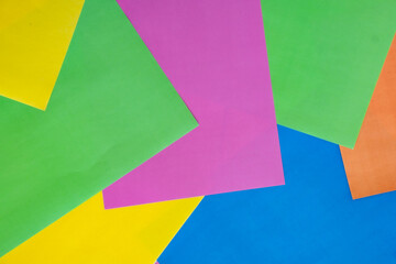 Colorful paper background. Top view of green, yellow, pink, blue and orange papers. Design for back to school concept.