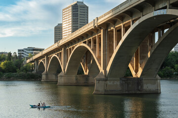 Naklejka premium Bridge spans a river with a boat in the water