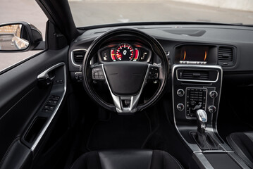 Modern car interior - drivers point of view. POV cockpit of auto: steering wheel and dashboard. 