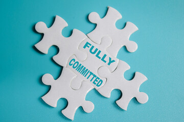 piece of jigsaw puzzle with word Fully committed. Business and finance concept