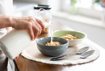 Woman Pouring Milk Into Cereal