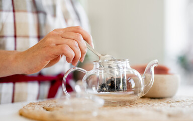 Woman Pouring Tea Into Mug