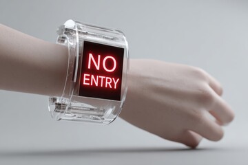 Futuristic bracelet displaying restrictive message on human arm.