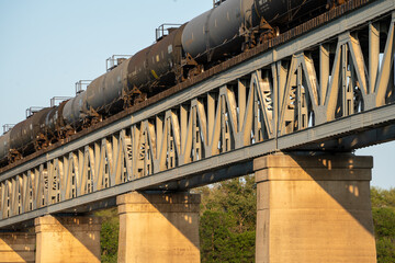 Train is crossing a bridge with a lot of metal