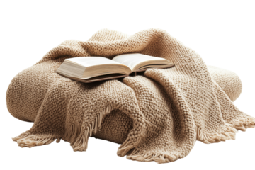 Book resting on a folded plaid blanket with fringes against white background