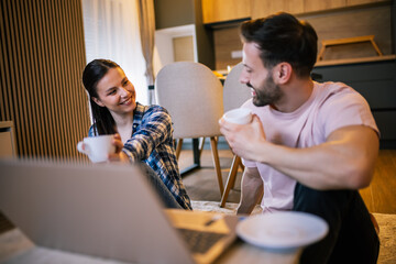 Smiling couple enjoying coffee together at home