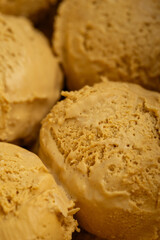 Creamy caramel ice cream scoops in rich golden tones, perfect for dessert advertising