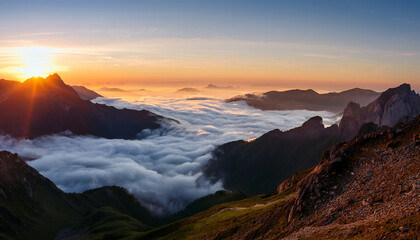 Sunrise Over Mountain Peaks With Clouds Rolling Through Low Valleys In A Serene Landscape During Early Morning Hours