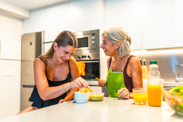 Grandmother and granddaughter enjoying time in modern kitchen