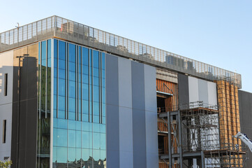 Exterior of a high-density data center campus under construction, showing glass panels, cooling...
