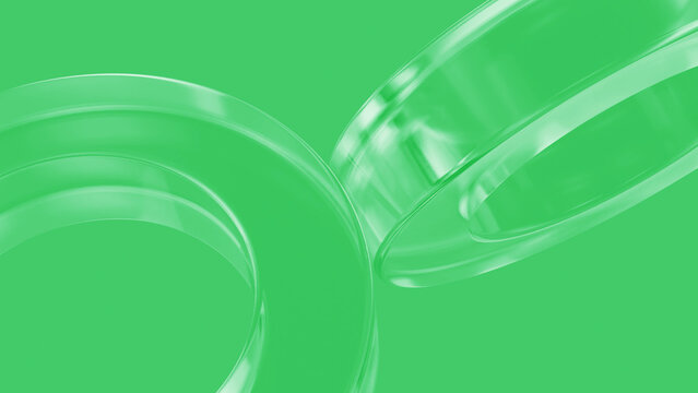 Abstract green glass rings are rotating on a green background, creating a visually appealing and modern design with a sense of movement and elegance