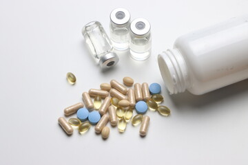 Vitamins pills and injectable in a white background