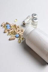 Vitamins pills and injectable in a white background