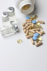 Vitamins pills and injectable in a white background