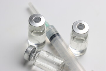 Vitamins pills and injectable in a white background