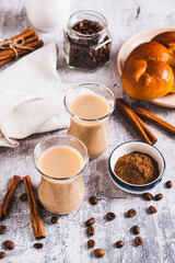 Yemeni coffee with spices and cream in glasses and crispy bread on the table vertical view