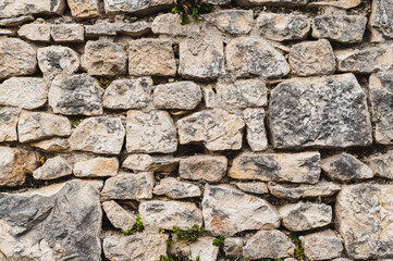 Gray stone wall made of old cobblestones, part of the fortress