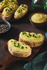 Green zucchini spread on bread sandwich on board on table vertical view
