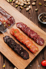 Assorted gourmet sausages sliced and vacuum packed on rustic wooden background with spices