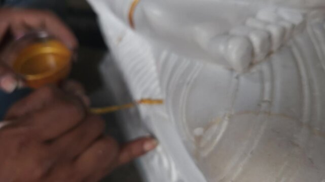 Indian artist doing paint on statue, Odisha, India