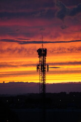 Naklejka premium Telecommunication tower at sunset with dramatic sky