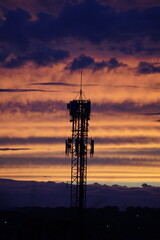 Telecommunication tower at sunset with dramatic sky