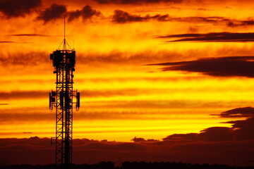 Telecommunication tower at sunset with dramatic sky