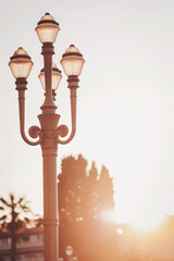 Elegant streetlamp illuminating a serene sunset in a coastal town, casting warm glows over the quiet surroundings with silhouettes of palm trees in the background