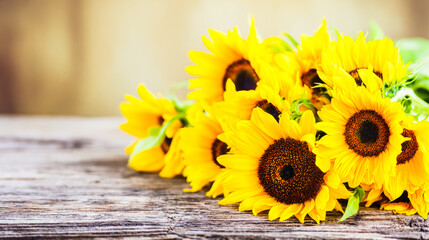 Sunflower bouquet bathed in golden morning light on a rustic wooden surface, radiating natural vibrancy.
