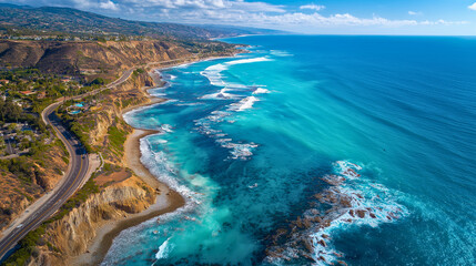 A turquoise ocean coastline meeting a rugged cliff. Aerial drone photography.