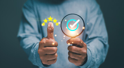 Customer satisfaction concept. Businessman show smiley face and five stars on thumb and holding...