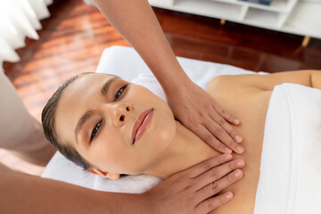 Caucasian woman customer enjoying relaxing anti-stress spa massage and pampering with beauty skin recreation leisure in day light ambient salon spa at luxury resort or hotel. Quiescent