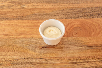 Small  cups with old-fashioned mustard mayonnaise, showing the mustard seeds visible in the creamy sauce