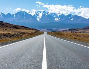 Asphalt Road Leading Towards Majestic Snow Capped Mountains under a Blue Sky in a Scenic Landscape