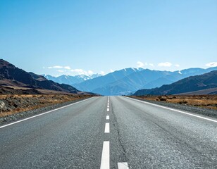Asphalt Road Leading Towards Mountain Range Under Clear Blue Sky