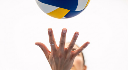 Athlete's hand reaches up to serve a vibrant volleyball, capturing the thrill of the game.