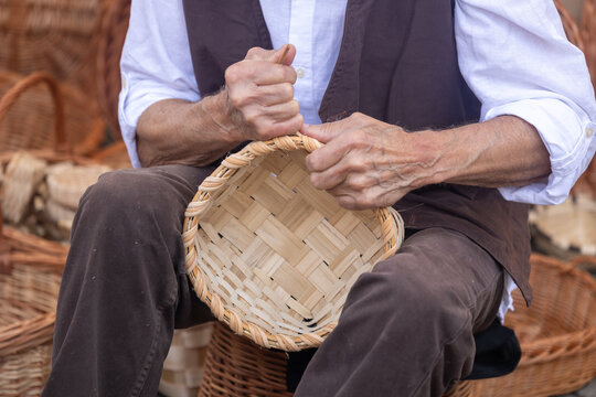 Basket weaver weaving a traditional wicker basket by hand
