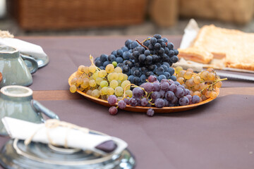 Fresh grapes displayed on wooden plate at outdoor market