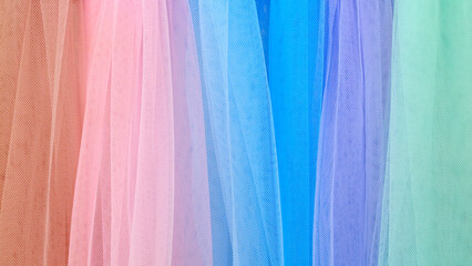 Row of colorful fabric with a light blue one in the middle. The other colors are pink, green, and...