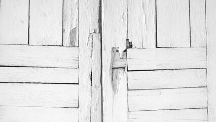 white door with a wooden frame. door is open and has a few holes in it. Scene is somewhat eerie and unsettling, as the door appears to be in disrepair