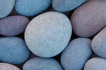 Pebbles stones on seashore as  texture background for design of web banner template page. many stones and they are different in color and size, dry stones illuminated by sun