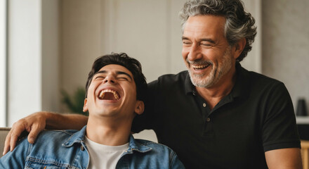 Fototapeta premium Happy father and son laughing together at home. Genuine joy and connection are evident in this heartwarming scene