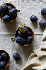 Ripe purple plums in a plate on a table top view indoors