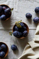 Ripe purple plums in a plate on a table top view indoors
