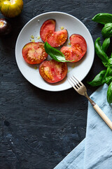 Red farm tomatoes on a plate top view