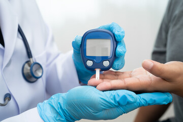 Doctor check diabetes from finger blood sugar level with finger lancet.