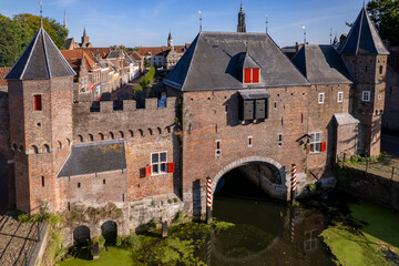 Closeup aerial view double gated medieval city entrance Koppelpoort structure in Amersfoort, The Netherlands, with the authentic rooftops of the historic center in the background